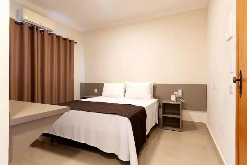 Quarto de casal com cortina cor de café e ar-condicionado